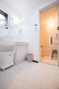 ein weißes Badezimmer mit Waschbecken und Dusche in der Unterkunft Kitakoiwakotate - Vacation STAY 20435 in Tokio