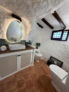 ein weißes Badezimmer mit Waschbecken und Toilette in der Unterkunft Magical Cave in Spain - Boutique Luxury Stay in Nature in Chinchilla de Monte-Aragón