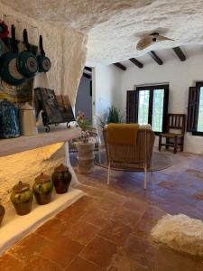 ein Wohnzimmer mit Töpfen und Vasen an einer Wand in der Unterkunft Magical Cave in Spain - Boutique Luxury Stay in Nature in Chinchilla de Monte-Aragón
