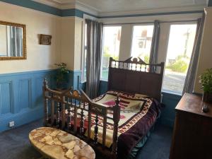 a bedroom with a bed and a large window at PERiVALE LODGE in Folkestone