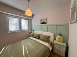 a small bedroom with a bed and two windows at New Cozy Apartment in Skopje
