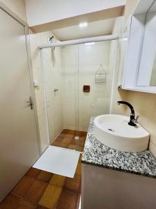 a bathroom with a sink and a shower at Apartamento Balneário Picarras vista mar, centro in Piçarras +54 photos