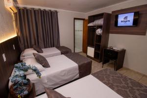 トレドにあるRosa's Hotelのベッド2台とテレビがあるホテルの部屋