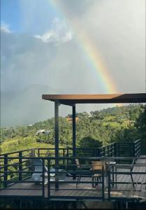 a rainbow over a deck with a table and chairs at Entire home for 2 with private pool and plenty of amenities in Rio Grande, Puerto Rico in Rio Grande
