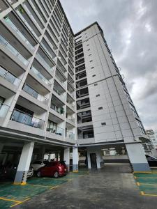 a tall building with cars parked in a parking lot at Urban Shell Retreat- Kileleshwa in Nairobi
