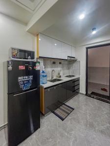 a kitchen with a black refrigerator and a sink at Urban Shell Retreat- Kileleshwa in Nairobi