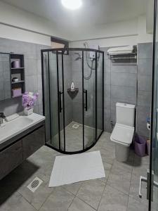 a bathroom with a shower and a toilet and a sink at Urban Shell Retreat- Kileleshwa in Nairobi +7 photos