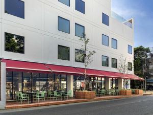 Un edificio con mesas y sillas delante. en ibis Chiang Mai Nimman Journeyhub, en Chiang Mai