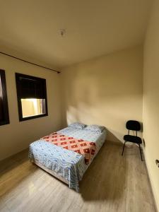 a bedroom with a bed and a chair in it at Casa do Guia - Casa compartilhada in Ouro Preto