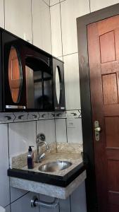 a kitchen counter with a sink and a microwave at Casa do Guia - Casa compartilhada in Ouro Preto