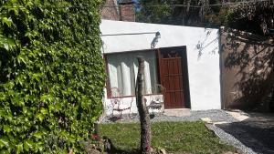 a building with a door and a bench in front of it at Apartamento en el jardín in Treinta y Tres