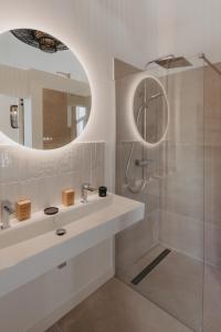a bathroom with a white sink and a mirror at Sainte Raphine in Fargues-Saint-Hilaire