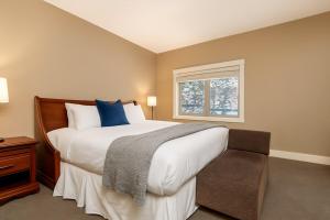a bedroom with a large bed and a window at Mountain Bliss Spacious 2BR with Pool and Hot Tub in Canmore
