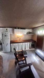 Una cocina con refrigerador y una mesa y sillas. en Apartamento en el jardín, en Treinta y Tres