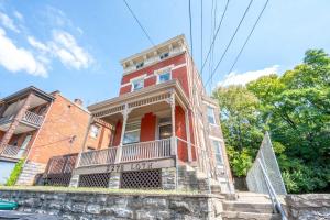 a red brick building with a balcony on a street at Queen City Suites 1 - For 3 in Cincinnati