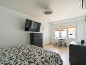 Un dormitorio con una cama y un escritorio con televisión. en Florida Home Private pool and Jacuzzi, en Playa del Inglés