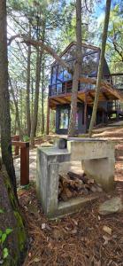 a log cabin in the woods with a bench in front at La Cabaña 16 Mazamitla in Mazamitla