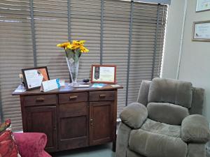 a room with a chair and a vase of flowers on a table at Greenfield in Klerksdorp