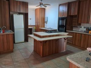 a kitchen with wooden cabinets and a white refrigerator at Greenfield in Klerksdorp