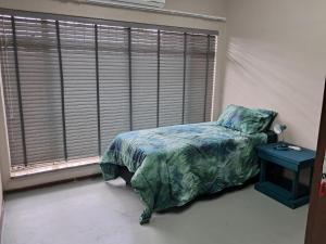 a bedroom with a bed and a large window at Greenfield in Klerksdorp