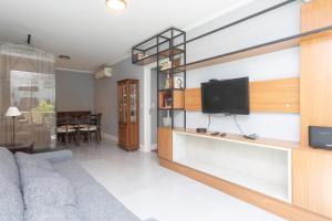 a living room with a couch and a flat screen tv at Apartamento Climatizado com Garagem e Wi-Fi in Auxiliadora