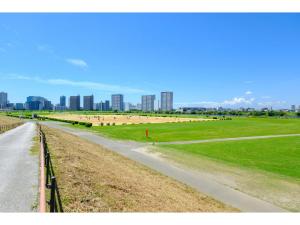 eine Straße in einem Feld mit einer Stadt im Hintergrund in der Unterkunft LIFE TOWN NISHIROKUGO - Vacation STAY 20474 in Tokio