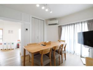 ein Esszimmer mit einem Holztisch und Stühlen in der Unterkunft LIFE TOWN NISHIROKUGO - Vacation STAY 20474 in Tokio