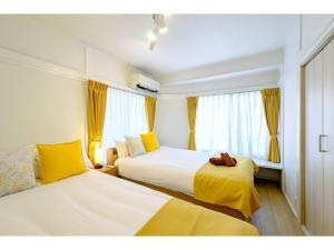 ein Hotelzimmer mit zwei Betten und einem Fenster in der Unterkunft LIFE TOWN NISHIROKUGO - Vacation STAY 20474 in Tokio