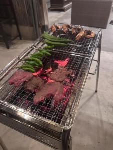 a grill with meat and green vegetables on it at KominkaGlamping NAYA - Vacation STAY 20482 in Chosei +31 photos