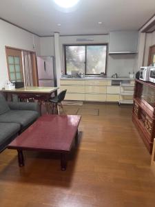a living room with a couch and a table and a kitchen at KominkaGlamping NAYA - Vacation STAY 20482 in Chosei