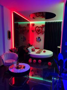 ein Zimmer mit rosa und violetten Lichtern und einem Bett in der Unterkunft 50m2 Suite in Capurso