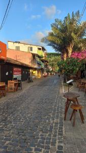 a cobblestone street with tables and benches on a street at Flat Lua Nova - Pituba I coração da vila e caminho praias in Itacaré