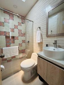 a bathroom with a toilet and a sink at Jardinhabs - JARDÍN in Filandia
