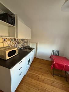 eine Küche mit Spüle und Mikrowelle in der Unterkunft 80 mq Gemütliche Wohnung in Wedel