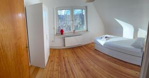 ein Schlafzimmer mit einem Bett und einem Fenster in der Unterkunft 80 mq Gemütliche Wohnung in Wedel