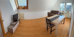 ein Wohnzimmer mit Tisch und Fernseher und Holzboden in der Unterkunft 80 mq Gemütliche Wohnung in Wedel