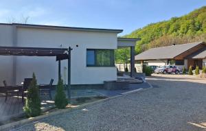 a white house with a patio and a car parked at Respiro Villas in Tîrgu Neamţ