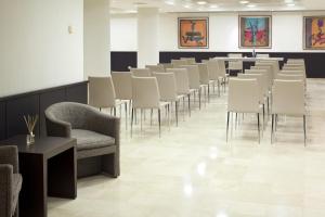 a row of chairs and tables in a waiting room at NH Ciudad de Santander in Santander