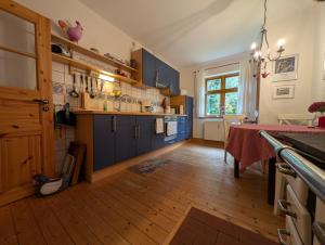 a kitchen with blue cabinets and a wooden floor at Hus in Huddel - Worpswede - Teufelsmoor in Osterholz-Scharmbeck