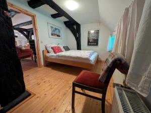 a living room with a bed and a chair at Hus in Huddel - Worpswede - Teufelsmoor in Osterholz-Scharmbeck