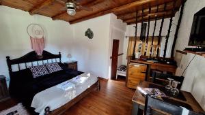 a bedroom with a black bed and a wooden floor at Las Acacias Refugio in La Falda +51 photos