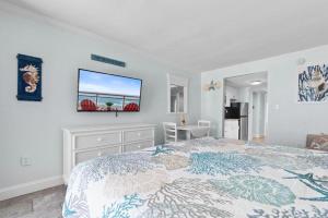 a bedroom with a bed and a tv on the wall at Sandy Horizon in Myrtle Beach +23 photos