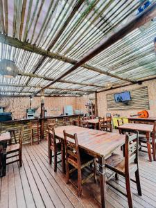 a dining room with wooden tables and chairs at Pousada Aimê Maresias in São Sebastião
