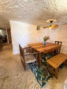 einem Holztisch mit zwei Stühlen und einer Vase aus Blumen in der Unterkunft Magical Cave in Spain - Boutique Luxury Stay in Nature in Chinchilla de Monte-Aragón