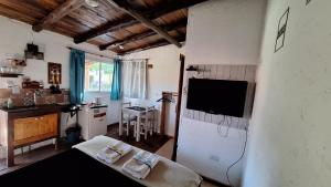 a living room with a tv on a wall at Las Acacias Refugio in La Falda