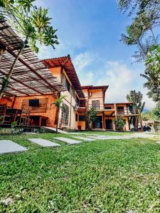 a house with a green lawn in front of it at Pousada Aimê Maresias in São Sebastião +290 photos