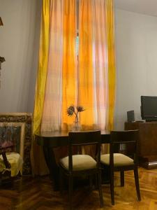 a dining room table with two chairs and a curtain at Vintage Room in private house in Bucharest