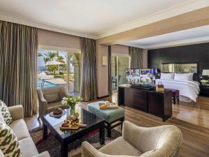 a hotel room with a king bed and a living room at Rixos Sharm El Sheikh - Adults Only 18 Plus in Sharm El Sheikh