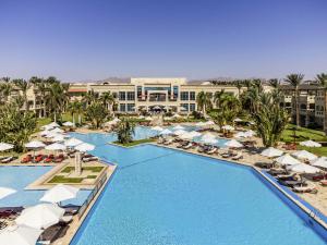 an aerial view of a resort pool with umbrellas and chairs at Rixos Sharm El Sheikh - Adults Only 18 Plus in Sharm El Sheikh