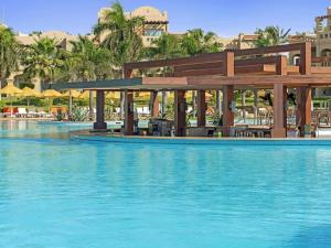 a swimming pool with a building in the background at Rixos Sharm El Sheikh - Adults Only 18 Plus in Sharm El Sheikh